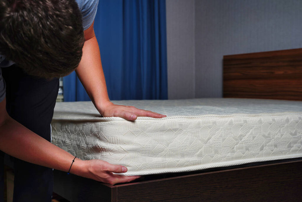 Young man choosing new orthopedic mattress close up - Photo, Image