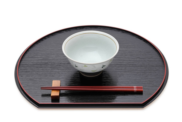Rijstkom met stokjes op dienblad, Traditioneel servies van Japan. geïsoleerd op witte achtergrond.  - Foto, afbeelding