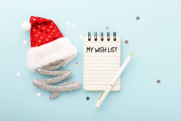My wish list with christmas decoration and pen on blue background - Photo, Image