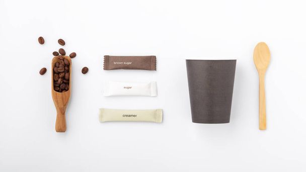 Eco taza de café y embalaje de papel de azúcar sobre fondo blanco, maqueta, vista superior - Foto, Imagen