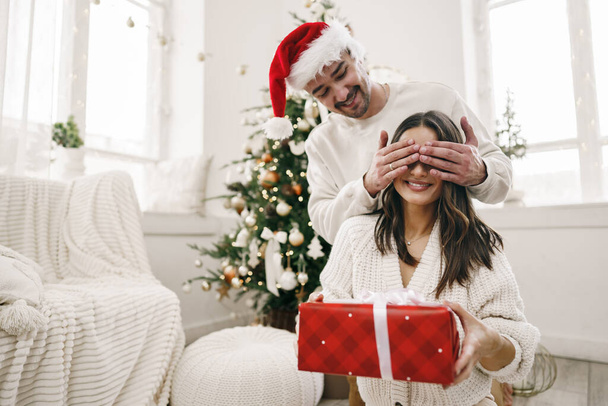 Young cheerful couple in love with present for Christmas - Foto, Bild
