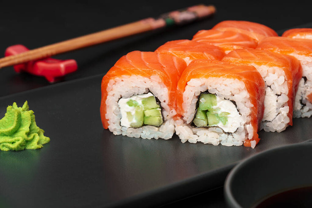 Fresh philadelphia sushi roll served on black plate - Φωτογραφία, εικόνα