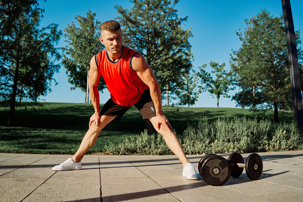 sporty man workout dumbbells exercise outdoors in the park - Φωτογραφία, εικόνα