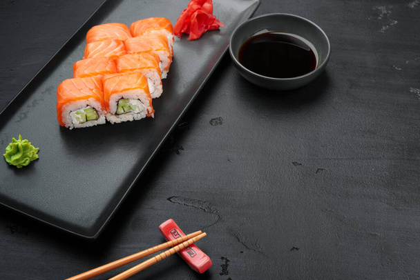Fresh philadelphia sushi roll served on black plate - Valokuva, kuva