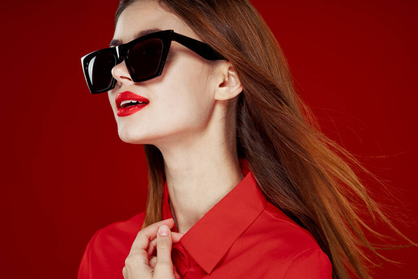 glamorous woman wearing sunglasses red shirt hairstyle model - Foto, afbeelding