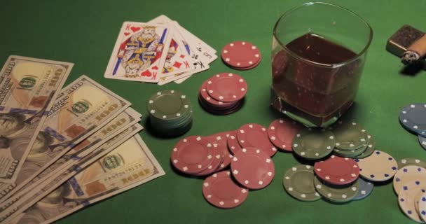 Chips, kártyák, egy pohár whiskey és pénz van a zöld játékasztalon. - Felvétel, videó
