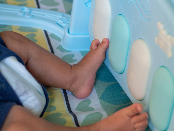 Baby's feet lying on the cushion - Foto, Imagen