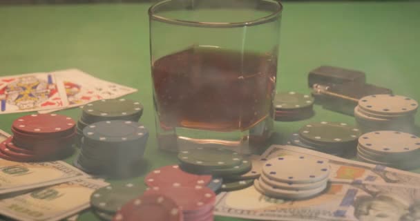 Chips, kártyák, egy pohár whiskey és pénz van a zöld játékasztalon. - Felvétel, videó