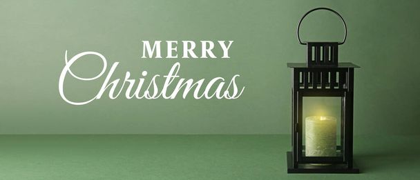 Hermosa linterna de Navidad con vela encendida sobre fondo verde con espacio para texto - Foto, imagen