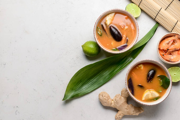 Kulhot mausteinen thaimaalainen keitto kevyellä taustalla - Valokuva, kuva