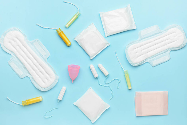Menstrual cup, pads and tampons on blue background - Foto, Bild