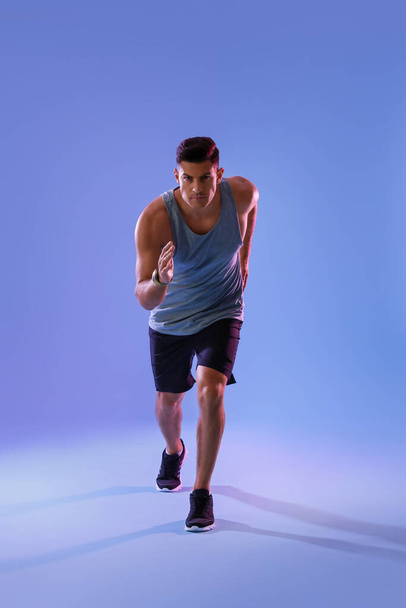 Sporty male runner on color background - Фото, изображение