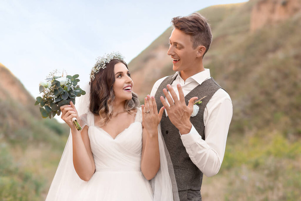 Boldog ifjú házasok, mutatja a jegygyűrű szabadban - Fotó, kép