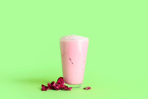Vidrio de sabroso café con leche rosa sobre fondo de color - Foto, imagen