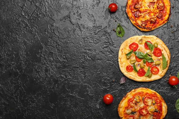 Différentes mini pizzas sur fond sombre - Photo, image