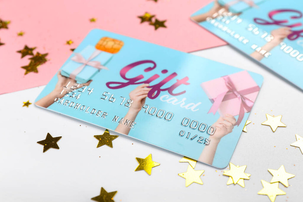 Gift card with confetti on color background, closeup - Photo, Image