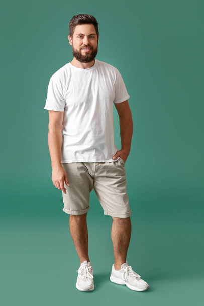 Handsome man in white t-shirt on green background - Photo, Image
