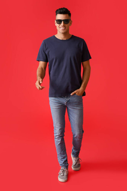 Handsome young man in stylish t-shirt on color background - Foto, Imagem