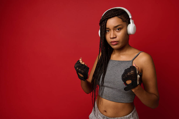 Fitness young African athlete young woman boxer with fit body preparing for boxing training. Women self defense. Cardio training concept in red colored background with copy space for advertising - Zdjęcie, obraz