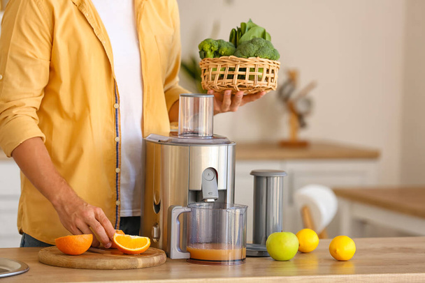 Young man preparing healthy juice in kitchen - Photo, Image