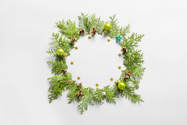 Beautiful wreath made of fir branches and Christmas decor on light background - Photo, Image