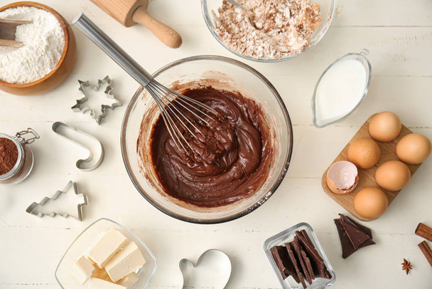 Cuenco con masa de chocolate fresco e ingredientes sobre fondo de madera blanca - Foto, Imagen