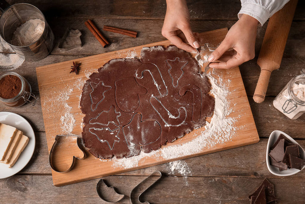 Женщина готовит шоколадное печенье на деревянном фоне - Фото, изображение