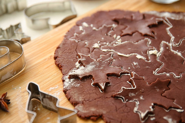 Placa de madeira com massa fresca para biscoitos de Natal de chocolate na mesa, close-up - Foto, Imagem
