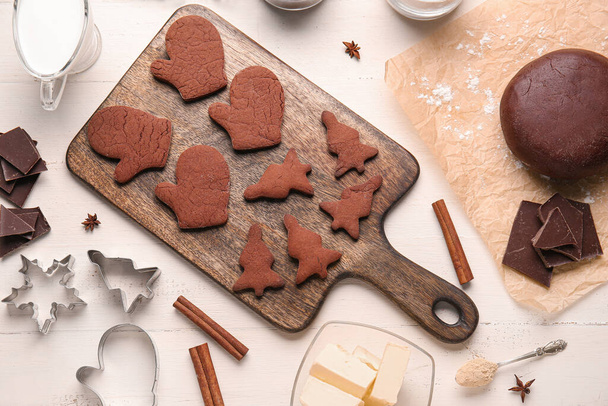 Placa com saborosos biscoitos de Natal de chocolate e massa no fundo de madeira branca - Foto, Imagem