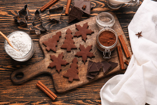 Board with tasty chocolate Christmas cookies on wooden background - Photo, Image