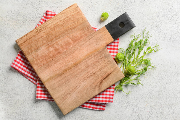 Tabla de cortar de madera con brotes de Bruselas, micro verde y servilleta sobre fondo blanco - Foto, imagen