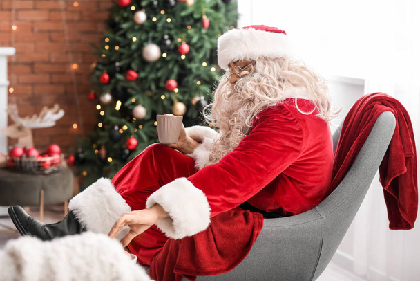 Άγιος Βασίλης τρώει νόστιμα μπισκότα με τσάι στο σπίτι - Φωτογραφία, εικόνα