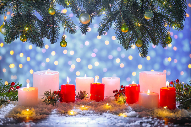 Όμορφη Χριστουγεννιάτικη σύνθεση με έλατα κλαδιά, χιόνι, κεριά και μπάλες που καίγονται στο τραπέζι κατά των θολή φώτα - Φωτογραφία, εικόνα