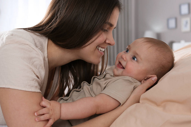 Happy young mother with her cute baby at home, closeup - Foto, immagini