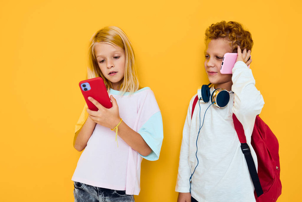Two kids boy and girl looking at the phone entertainment communication concert of addiction of children and gadgets - Фото, изображение