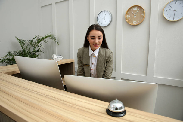 Beautiful receptionist working at counter in hotel - Photo, Image