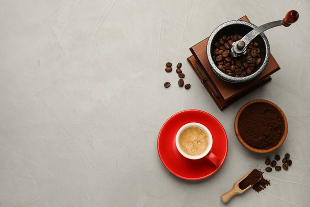 Flat lay composition with coffee grounds and roasted beans on light table, space for text - Foto, Imagen