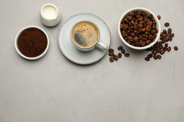 Flat lay composition with coffee grounds and roasted beans on light table, space for text - Foto, Bild