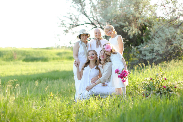 Americano nonna abbracciare figlie e nipoti, indossando vestiti bianchi al di fuori. - Foto, immagini