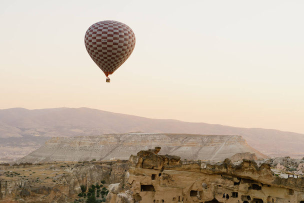 Летящий воздушный шар на вершине белых гор в Каппадокии, Турция - Фото, изображение