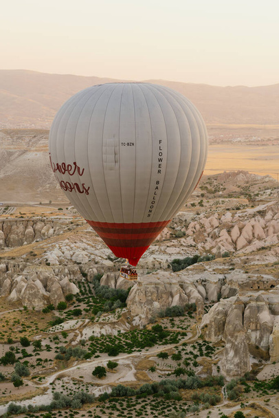 Vliegende luchtballon op de top van witte bergen in Cappadocia, Turkije - Foto, afbeelding