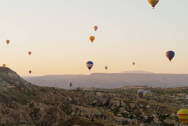 Flying hot air balloon on the top of white mountains in Cappadocia, Turkey - 写真・画像