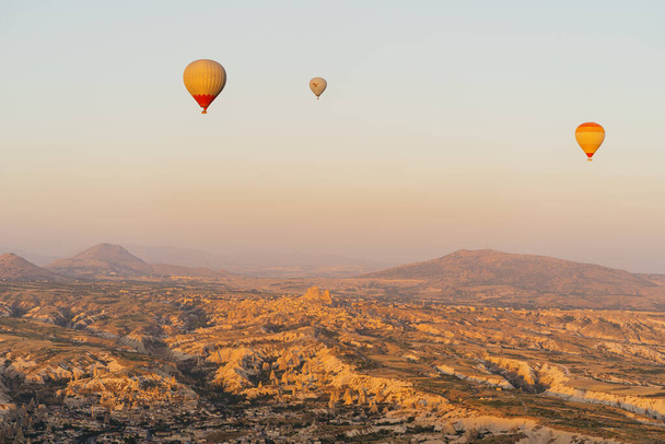 Flying hot air balloon on the top of white mountains in Cappadocia, Turkey - Φωτογραφία, εικόνα