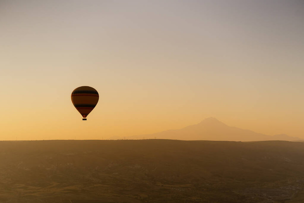Flying hot air balloon on the top of white mountains in Cappadocia, Turkey - Фото, зображення