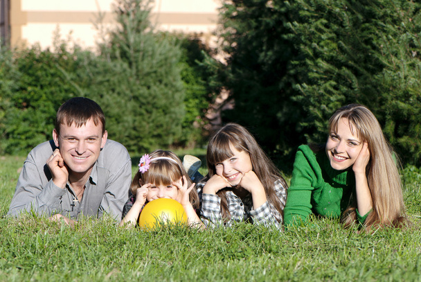gelukkige ouders en dochters in park - Foto, afbeelding