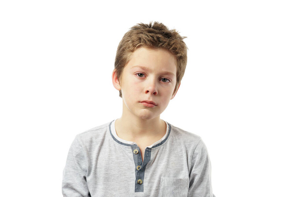 retrato de un niño triste aislado sobre fondo blanco. lindo niño caucásico tristemente mirando a la cámara - Foto, imagen