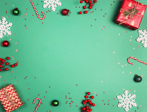 Christmas frame made of gifts and decorations on a green background. Copy space, top view. - Фото, изображение