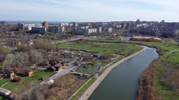 Pohled z ptačí perspektivy na město. Můžete vidět městské ulice, řeku a architekturu. Město Mariupol na Ukrajině - Záběry, video