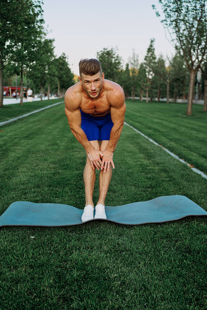 sporty man in shorts in the park working out outdoors - Фото, зображення