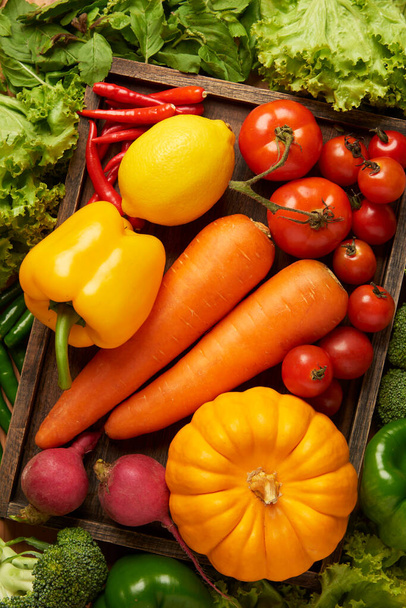 zöldség fogalom különböző színes zöldségek kerülnek egy vágódeszkára sok zöldség felett. - Fotó, kép